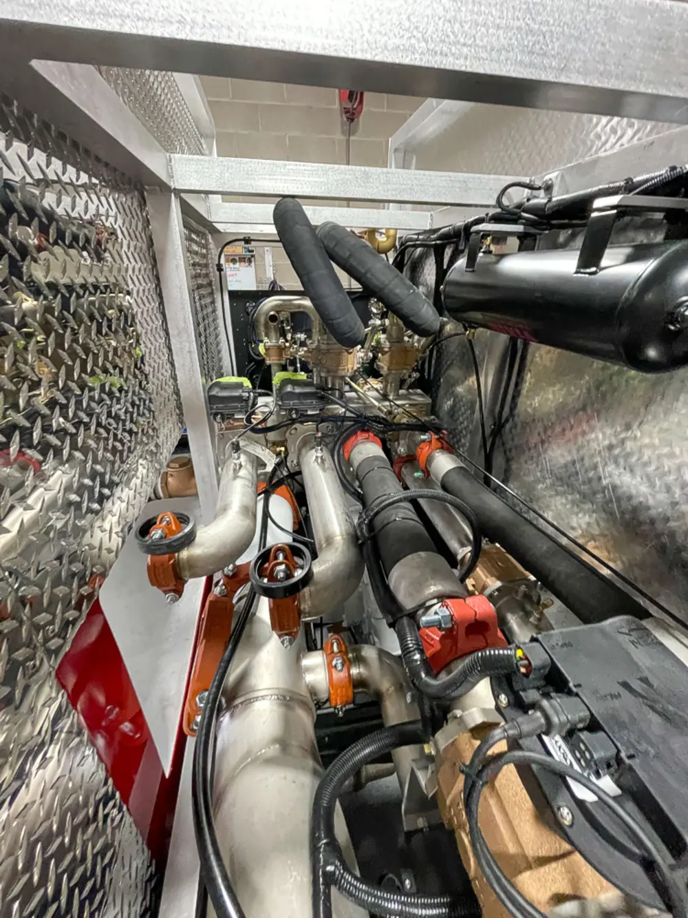 Exterior view of small fire truck showing cab, body compartments, and wheel/tire area.